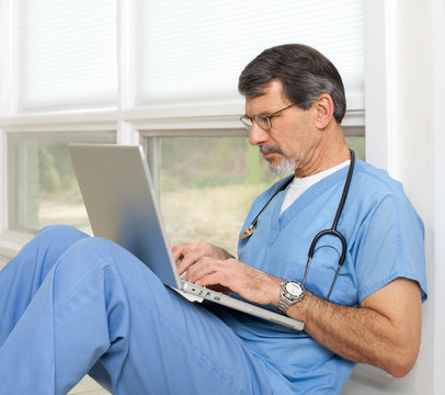 Doctor Reviewing And Researching On Laptop Computer