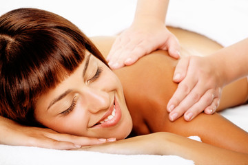 Close-up of a beautiful smiling woman getting a massage.
