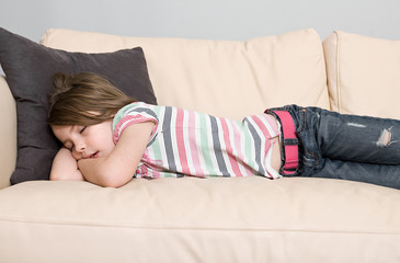 Obraz na płótnie Canvas Young Child Asleep on a Leather Sofa