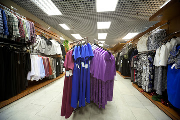 Dresses, blouses, jackets and suits in shop of female clothes