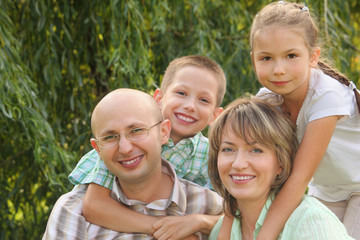 cheerful family with two children in early fall park.