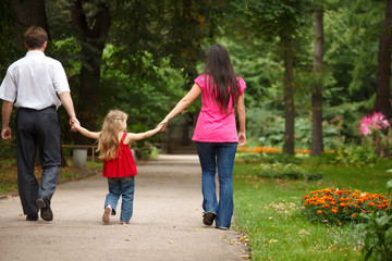 Fototapeta premium Parents together with daughter walk on summer garden.