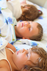 Obraz na płótnie Canvas children three together sleeping on bed in cosy room, lying on b