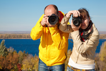 Man and girl photographed in nature. Lenses aimed at viewer.
