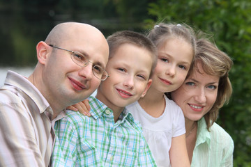 Fototapeta na wymiar family with two children in early fall park near pond