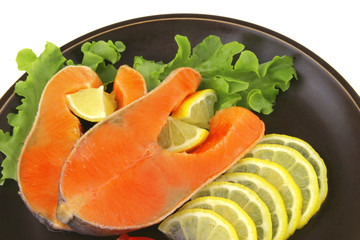 two salmon steak on dark dish