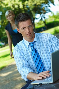 Businessman working with laptop in park