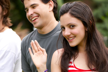 Portrait young happy teenage girl at the park with friends