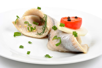 some fresh organic herring on a white plate