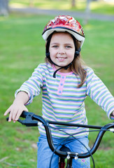 Obraz premium Joyful little girl riding a bike