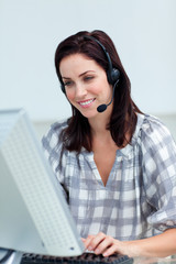 Charming businesswoman with headset on working at a computer