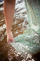 woman getting her dress wet in the water