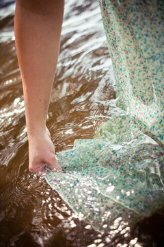 woman getting her dress wet in the water