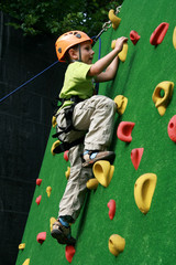 child climbing on a wall in an outdoor climbing center