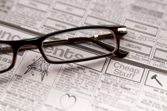 Reading glasses on a newspaper page