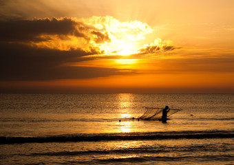 Fototapeta premium Silhouette Of Fisherman In The Sea