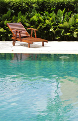 A wooden pool chair by the poolside