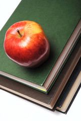 red apple on stack of book