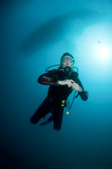 Fototapeta na wymiar woman scuba diver swimming in clear blue water