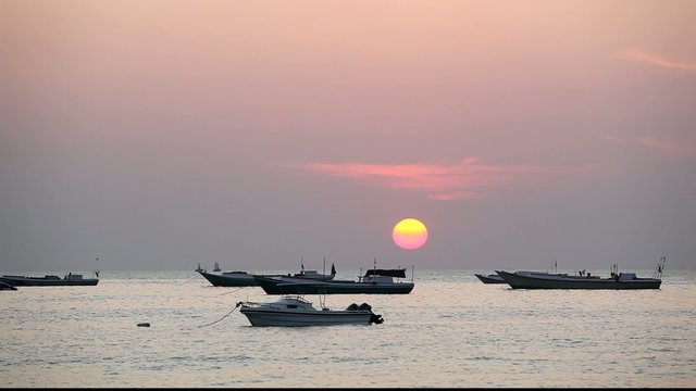 A number of fishing boats during sunset