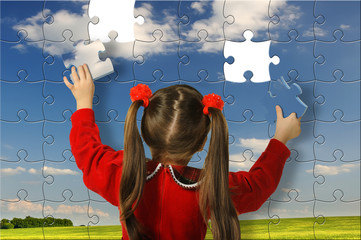 The girl assemble big puzzle