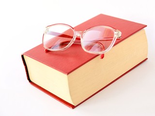 thick red book and glasses