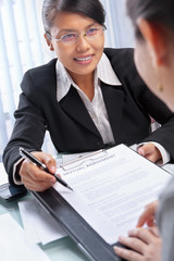 Asian businesswoman explaining document to client