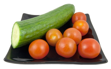 cucumber and tomatoes on plate isolated on white