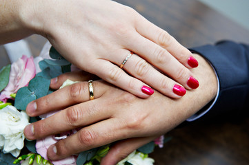 Obraz na płótnie Canvas Hands with wedding rings newlyweds