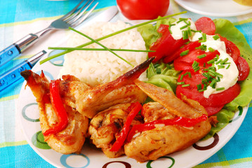 baked chicken wings with rice and tomato salad