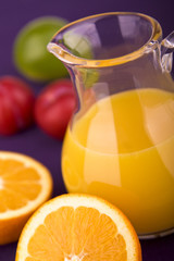 Karaffe mit Orangensaft und Pflaumen