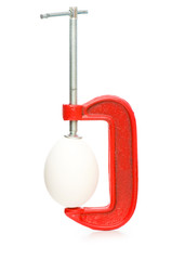 Strength concept with egg and clamp on white