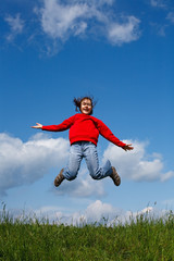 Girl jumping, running against blue sky