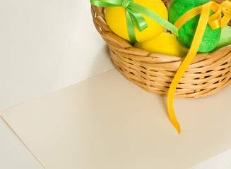 Painted easter eggs in basket on white background with copy spac