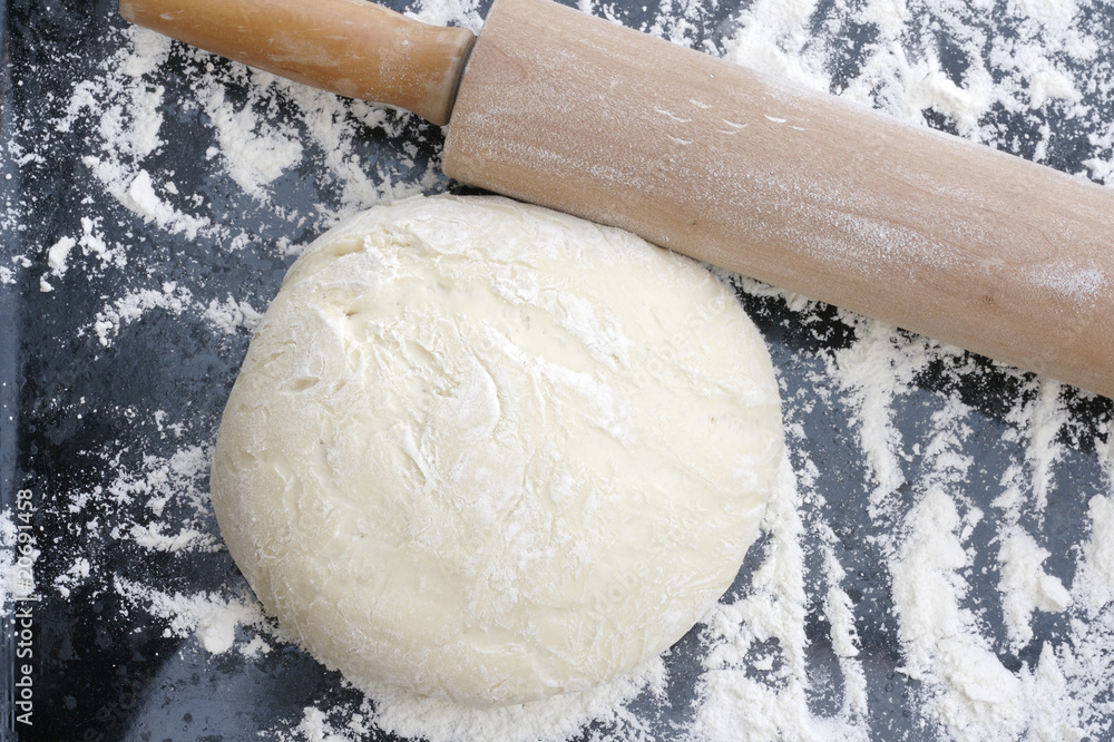 Wall mural rolling-pin and fresh dough sprinkled with flour.