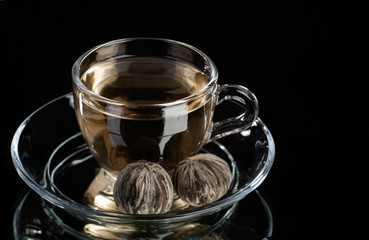 Cup of pure green tea over abstract black background