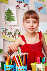 Child  with colour pencil in play room.