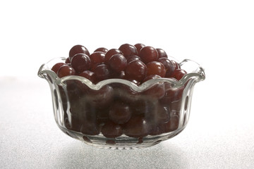 Glass bowl of red grapes.