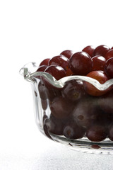 Glass dish of red grapes.