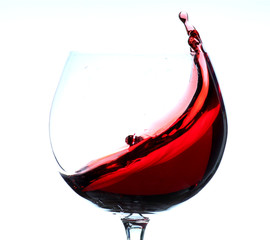 moving red wine glass over a white background