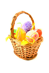 Basket with colorful easter eggs over white background