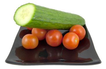 black plate with salad ingredients on white background