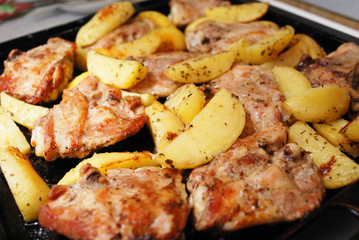 Fried chiken with potato chips closeup. Spices added.