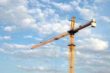 Construction crane against the sky with clouds