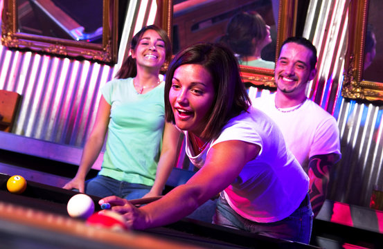 Young adults at a nightclub playing pool