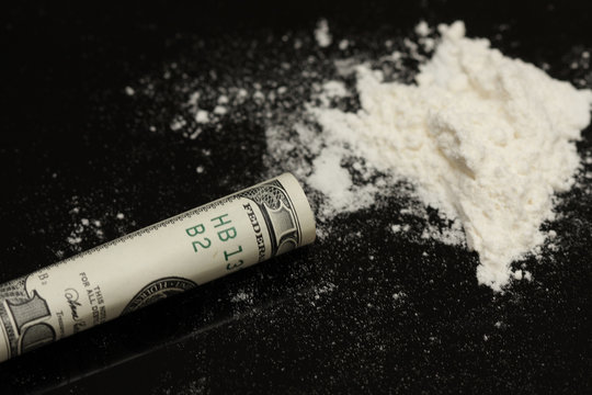 Cocaine and rolled hundred  on black background