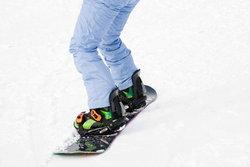 Legs snowboarder on a mountain road
