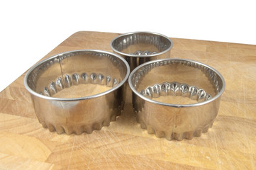 pastry cutters on chopping board isolated on white