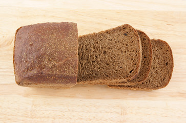 Slices of rye-bread on wooden background