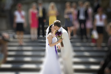 Groom and bride kissing on stairs of palace